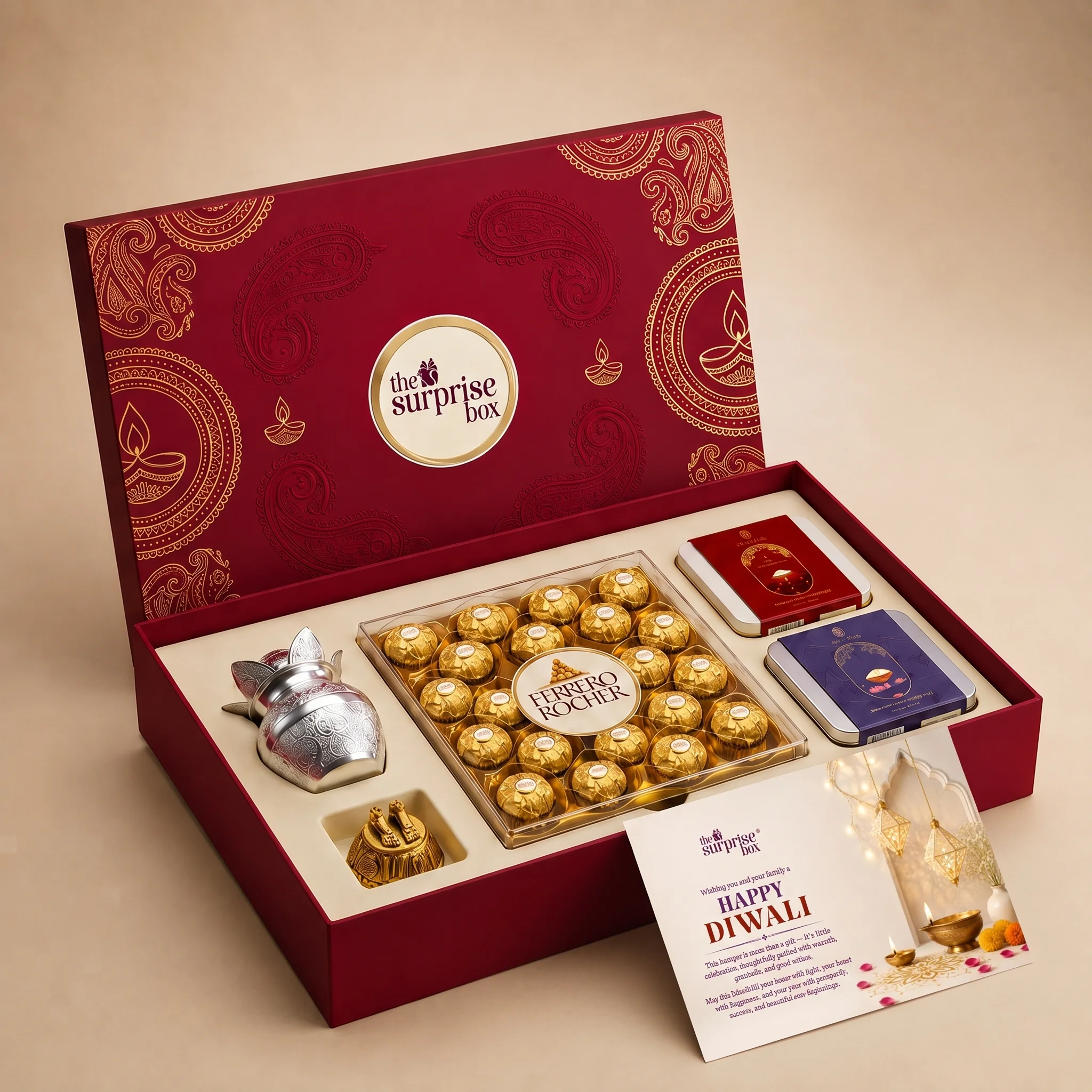 Open red gift box with gold decorative pattern containing wrapped chocolates and a card reading "The Surprise Box" and Happy Diwali text on the front panel.