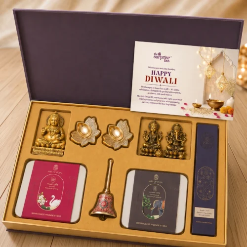 4_Puja Gift Kits Open gift box revealing gold incense-stick tins and small Hindu deity figurines with festive cards and decorations inside a purple box.